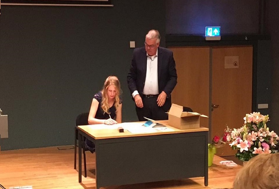 Nynke ondertekend haar diploma in het Auditorium