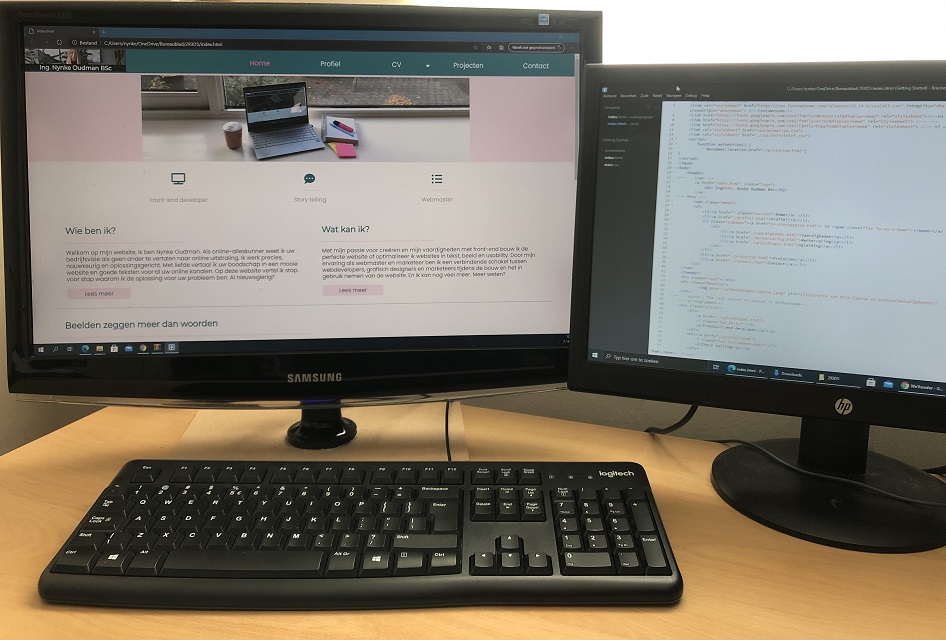 Computer met 2 schermen, waarop de code en de website te zien is